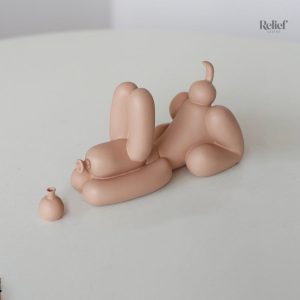 Figurine de chien joyeux tenant un ballon