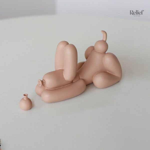 Figurine de chien joyeux tenant un ballon