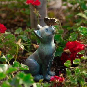 Statue en plein air de chat avec un papillon coloré