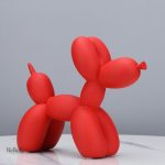 Statue de chien joyeux tenant un ballon