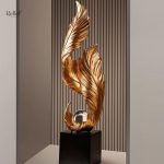Statue dorée design en forme de plume sur socle