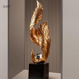 Statue dorée design en forme de plume sur socle