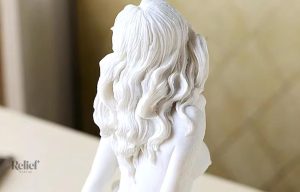 Figurine artistique femme nue, assise sur une base stylisée