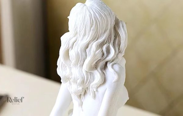 Figurine artistique femme nue, assise sur une base stylisée